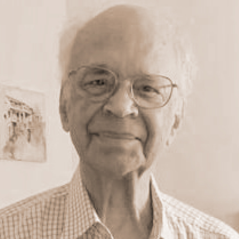 Sepia portrait of an elderly man wearing glasses and a plaid shirt, smiling subtly.