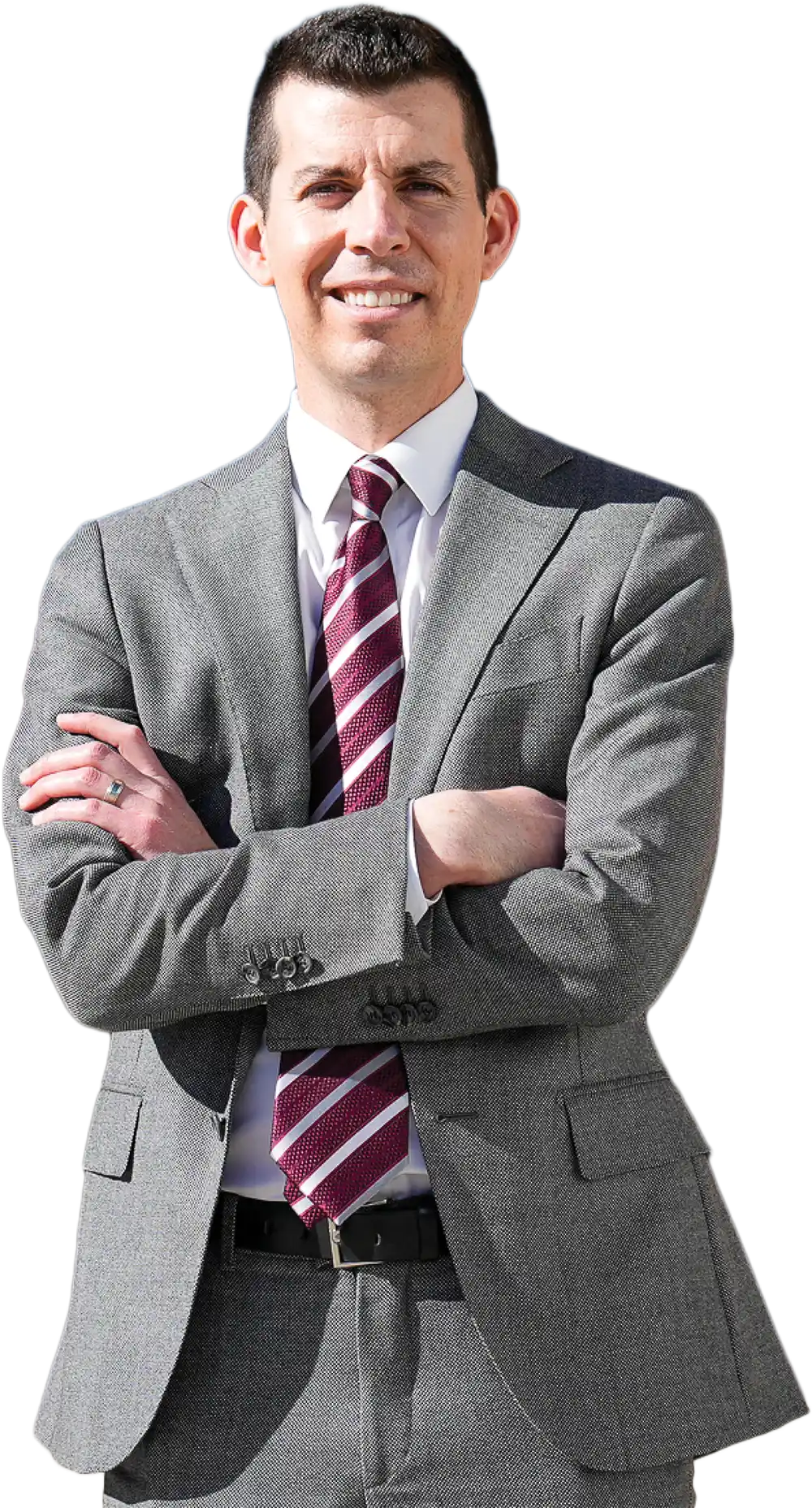 A man with short hair wearing a grey suit, white dress shirt, and a striped maroon and white tie, posing with arms crossed.