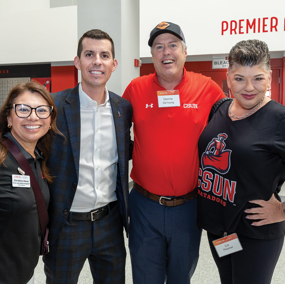 A group of four people, including CSUN staff and alumni, posing together at an event.