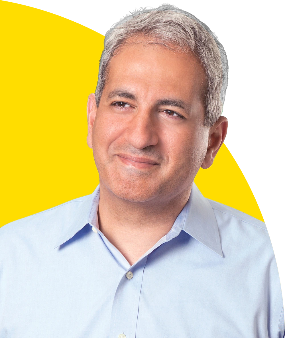 Portrait of Ilan Haimoff with grey hair wearing a light blue button-down shirt.