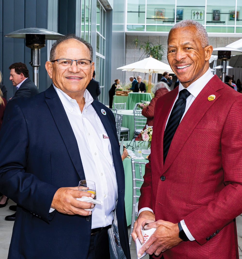 Carlos Fuentes and Robert D. Taylor smiling together at an outdoor event reception.